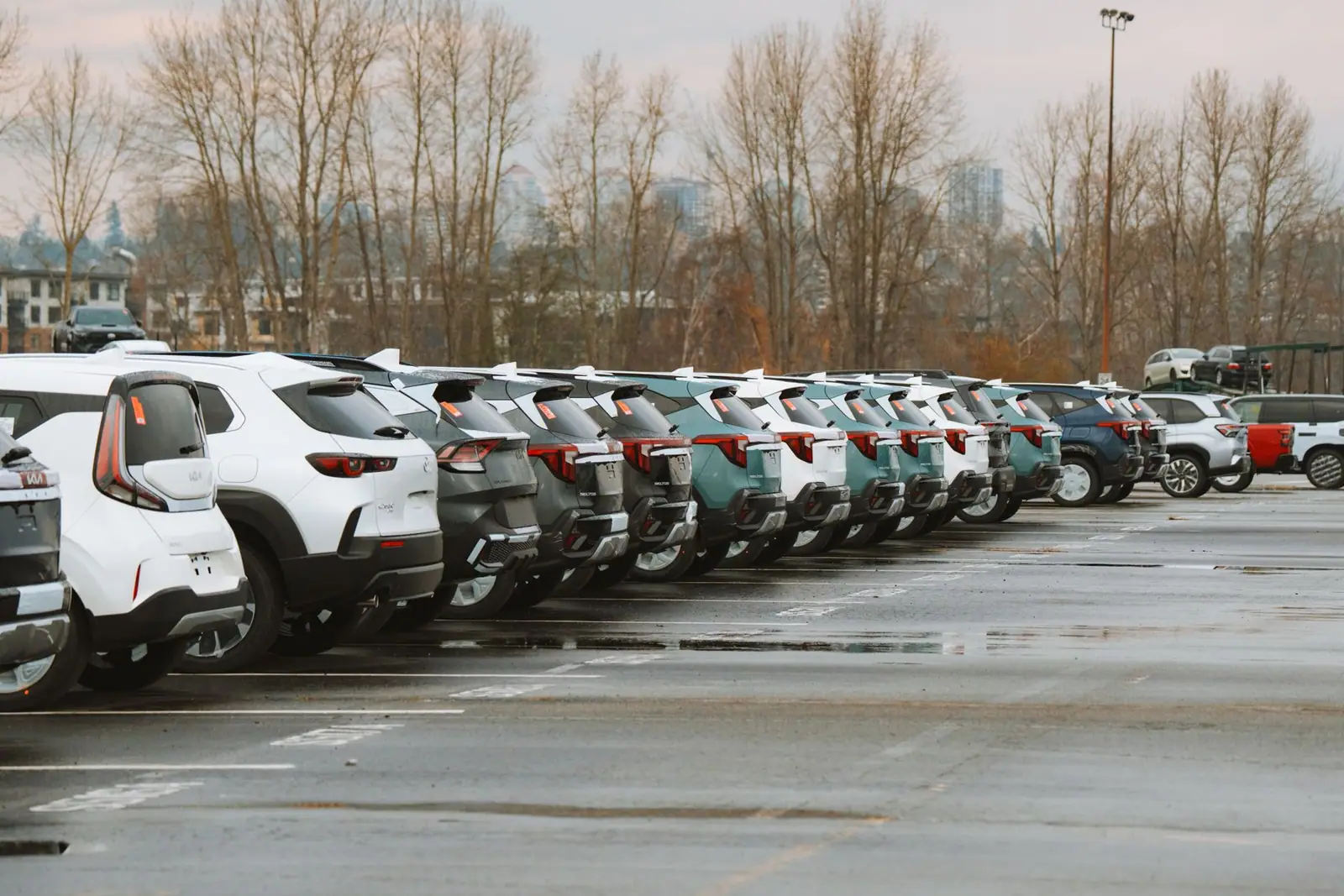 A row of cars parked in an outdoor car park on a cloudy day