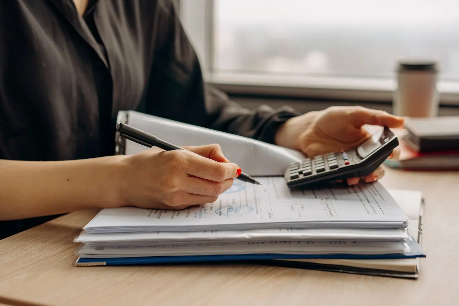 A calculator resting beside paperwork on a desk