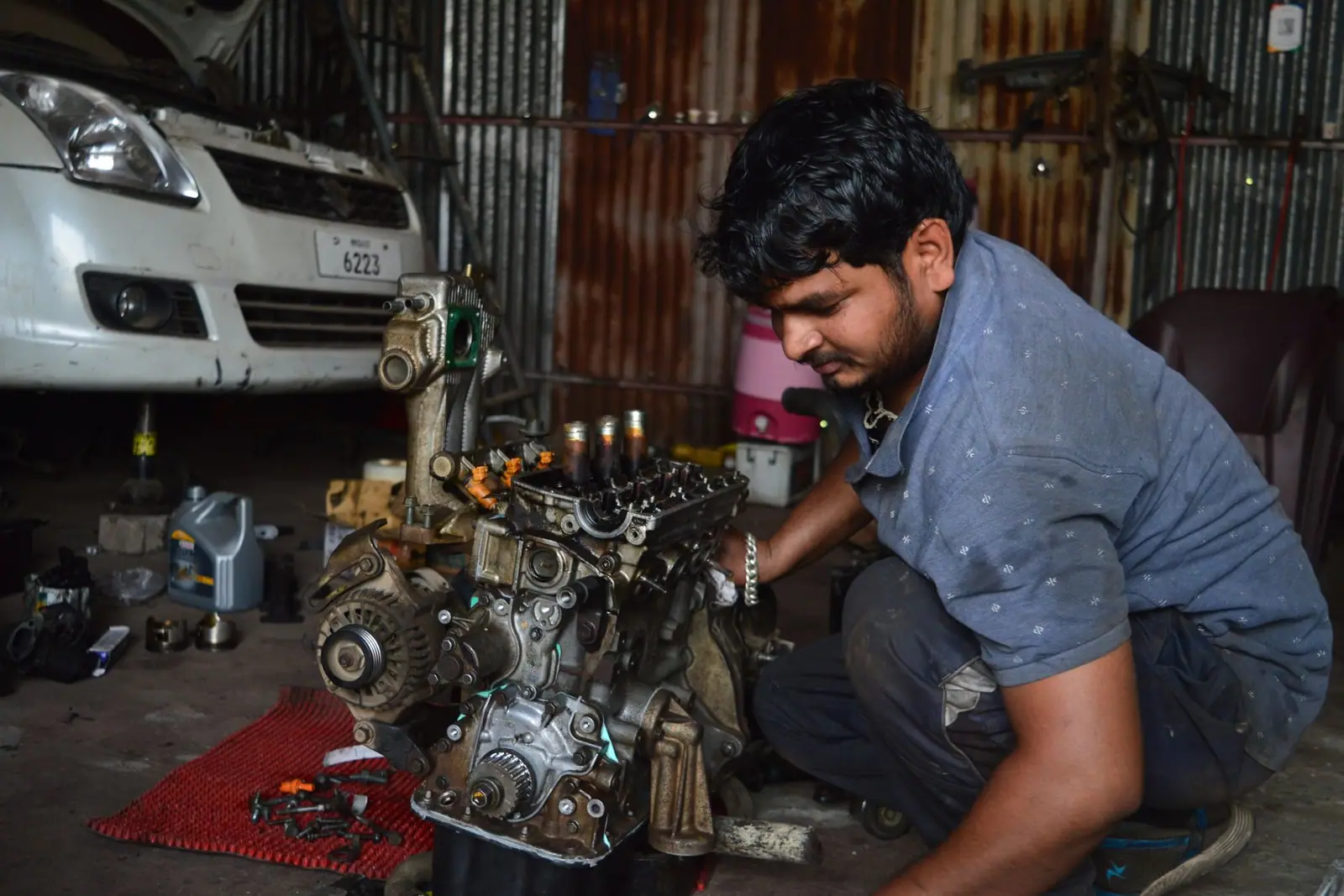 A mechanic working on an engine assembly in a workshop